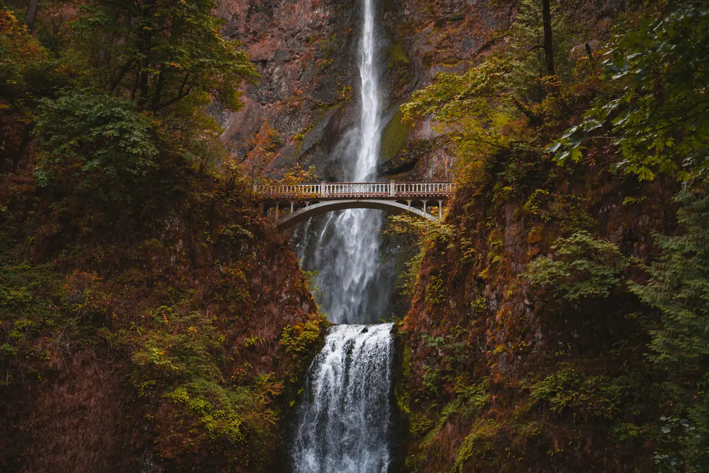 Multnomah Falls plunging in two tiers past the stone Benson Bridge in the Columbia River Gorge